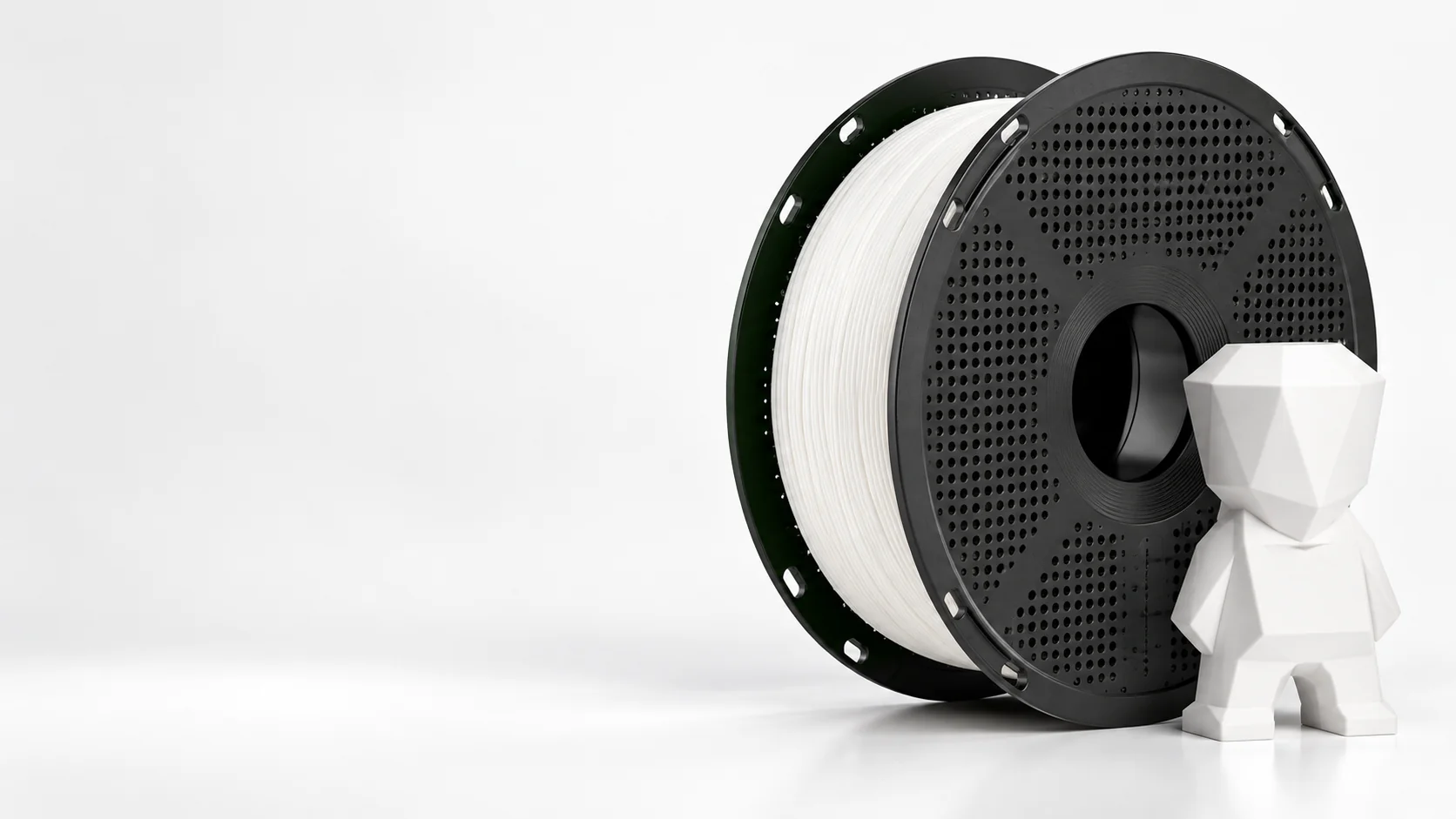 A filament spool beside a small geometric 3D-printed figure